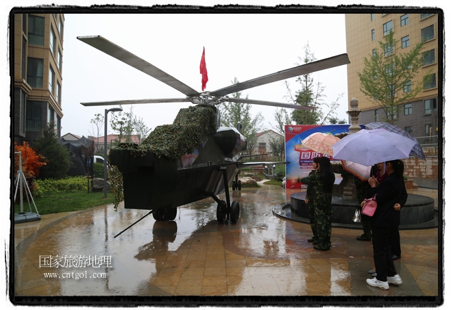 小區(qū)突然出現(xiàn)“飛機(jī)坦克”，其中殲15艦載戰(zhàn)斗機(jī)一架、99式主戰(zhàn)坦克一輛、武直-10武裝直升機(jī)一架，吸引了眾多市民雨中圍觀(guān)、合影。