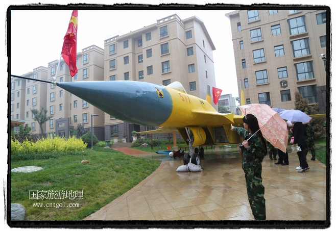 小區(qū)突然出現(xiàn)“飛機(jī)坦克”，其中殲15艦載戰(zhàn)斗機(jī)一架、99式主戰(zhàn)坦克一輛、武直-10武裝直升機(jī)一架，吸引了眾多市民雨中圍觀(guān)、合影。